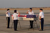 US military honor guards salute over the flag draped coffin bearing the recovered remains of suspected American airmen during a repatriation ceremony at the Mandalay International Airport on March 12, 2019. Photo: AFP
