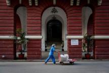 A staff member pushes a food trolley to deliver breakfasts at the Yangon General Hospital, in Yangon, Myanmar. Photo: EPA