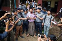 (File) Detained Reuters journalist Wa Lone (C) talks to media while being escorted by police as he leaves the court after his trial hearing in Yangon, Myanmar, 02 July 2018. Photo: Lynn Bo Bo/EPA
