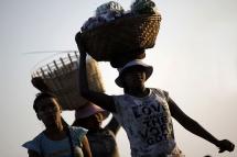 Myanmar women carry baskets loaded with fruit to sell. Photo: Lynn Bo Bo/EPA
