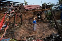 A Rohingya woman stands in her destroyed house at Basara refugee camp in Sittwe on May 16, 2023, after cyclone Mocha made a landfall. Photo: AFP