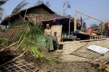 A Rohingya woman and a boy stand among the debris of a damage house at the Thae Chaung Muslim internally displaced people (IDPs) camp near Sittwe, Rakhine State, Myanmar, 17 May 2023. Photo: EPA
