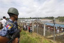 (File) Myanmar border guard police stands guard near the fence of Rohingyas refugees makeshift houses at the 'no man's land' zone between the Bangladesh-Myanmar border in Maungdaw district, Rakhine State, western Myanmar, 24 August 2018. Photo: EPA