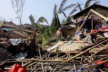 A Rohingya woman stands near a damaged house at the Thae Chaung Muslim internally displaced people (IDPs) camp near Sittwe, Rakhine State, Myanmar, 17 May 2023. Photo: EPA