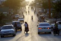 The sun setting down as people drive and ride around a busy road at Myawaddy town, Karen State. Photo: Lynn Bo Bo/EPA
