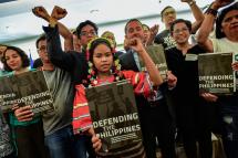 Campaigner Ben Leather (centre R) from international rights watchdog Global Witness, along with indigenous peoples, campaigners and their supporters, holds up a newly released human rights report during a press conference in Manila on September 24, 2019. Photo: AFP