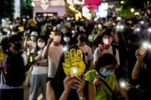 People hold up their phones with the light on in the Causeway Bay district of Hong Kong on June 4, 2021, after police closed the venue where Hong Kong people traditionally gather annually to mourn the victims of China's Tiananmen Square crackdown in 1989 which the authorities have banned citing the coronavirus pandemic and vowed to stamp out any protests on the anniversary. Photo: AFP