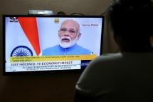 An Indian women watches a live broadcast of Indian Prime Minister Narendra Modi's address to the nation, in Bangalore, India, 19 March 2020. Photo: EPA
