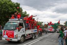 Supporters of the National League for Democracy (NLD) party on a motorcade pass supporters of the opposition Union Solidarity and Development Party (USDP), seen at right, during a campaign in Wundwin, near Mandalay on September 19, 2020. Photo: Kyaw Thet Zin/AFP