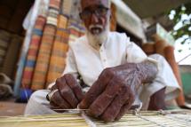 An elderly Pakistani man makes wooden blind at a market, on the eve of International Day of Older Persons, in Karachi, Pakistan 30 September 2020. Photo: EPA