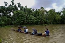  Locals use a boat to reach towards a shelter after their houses were submerged in flood waters at Maulovir Para, Cox's Bazar on July 30, 2021 after monsoon floods and landslides have cut off more than 300,000 people in villages across southeast Bangladesh and killed at least 20 people including six Rohingya refugees. Photo: AFP