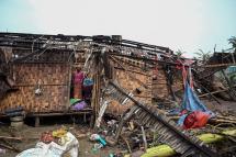 A Rohingya woman stands in her damaged house at the Basara refugee camp in Sittwe after Cyclone Mocha made landfall. Photo: AFP