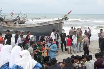 A wooden boat carrying at least 69 Rohingya, many of them women and children, lies moored on a beach after landing on Indonesia's western coast. - AFP
