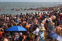 This picture taken on July 20, 2019 shows people relaxing on Sam Son beach in Thanh Hoa province. There are few beaches in northern Vietnam, and Sam Son in Thanh Hoa province has long been a popular destination for Vietnamese daytrippers. But its beauty has proven both a blessing and a curse, leading vacationers to pack out the 16 kilometer-long (9.9 mile-long) beach. Photo: Nhac Nguyen/AFP