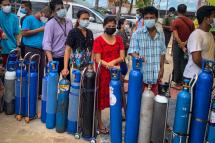 This picture taken on July 14, 2021 shows people waiting to fill empty oxygen canisters at a location donating oxygen at no cost in Yangon, amid a surge in the number of Covid-19 coronavirus cases. Photo: AFP