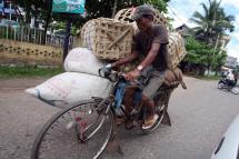 A tri-shaw drivers ride his tri-shaw loaded with goods in Bago, Myanmar. Photo: Nyein Chan Naing/EPA
