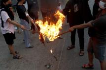 Demonstrators burn the Myanmar National flag during an anti-military coup protest in Yangon, Myanmar, 24 November 2021. Photo: EPA