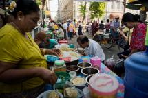 The aim is to help support small businesses and the poor -  A vendor prepares street food on her side walk stall at a market in Yangon. Photo: Romeo Gacad/AFP
 
