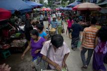 People walk through a street market in Yangon. Photo: AFP
