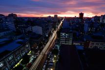 A photo taken with a long exposure shows cars driving along a busy road at sunset in Yangon. Photo: Lynn Bo Bo/EPA
