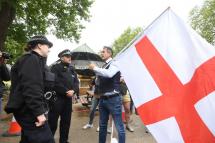 (File) An anti-lockdown protester holding a large Flag of England argues with police officers during a demonstration in Hyde Park in London, Britain, 16 May 2020. Photo: EPA