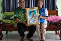 Kham Pornnikhom (L) and Banyen Srichanil hold a photo of their three-year-old grandson Nannaphat "Stamp" Songsermin, who was slaughtered in a mass killing at a nursery on October 6, 2022  / Photo: AFP