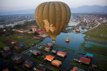 This aerial photo taken from a hot air balloon shows a hot air balloon flying over traditional houses on stilts on Inle lake in Shan State on February 18, 2019. Photo: Ye Aung Thu/AFP