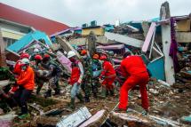 Rescuers and volunteers carry tubes out of the ruin of a collapsed building hit by the 6.2 magnitude earthquake in Mamuju, West Sulawesi, Indonesia, 17 January 2021. Photo: EPA