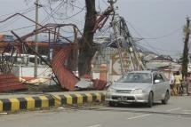 A car is parked near damaged structure after cyclone Mocha made landfall in Sittwe, Rakhine State, Myanmar, 15 May 2023. Photo: EPA