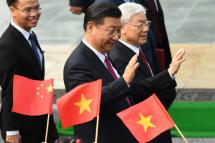 Chinese President Xi Jinping (C) and Vietnam's Communist Party Secretary General Nguyen Phu Trong (R) wave during a welcoming ceremony. Photo: AFP