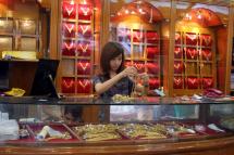 Myanmar vendor arranging a display of gold jewellery at a jewellery shop at Chinatown in downtown Yangon. Photo: AFP
