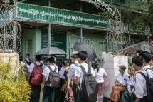 Students wait at a school entrance in Sittwe, capital of western Rakhine State on June 1, 2021. Schools in Myanmar opened on June 1 for the first time since the military seized power, but teachers and students are set to defy the junta's calls for full classrooms in a show of resistance. Photo: AFP