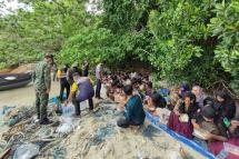 This handout from the Royal Thai Navy taken on June 4, 2022 and released on June 5 shows members of the Thai Navy and park officials offering food to Rohingya found stranded on the Thai island of Koh Dong. Photo: AFP