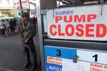 A Sri Lankan security official stands guard outside a fuel station that ran out of petrol in Colombo, Sri Lanka on Monday. Photo: AFP