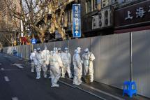 Health workers on a closed off street in an area under lockdown following an outbreak in Shanghai on March 15. Photo: AFP