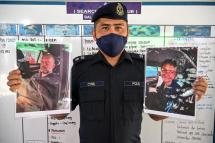 Mersing district police chief Cyril Edward shows pictures of two divers found alive, French national Alexia Alexandra Molina (R) and British national Adrian Peter Chesters (L), with a Dutch teen still missing, after a press conference in Mersing on April 9, 2022, during the search to locate three divers at sea after they went missing off Malaysia's southeast coast near Mersing in Johor state. Photo: AFP
