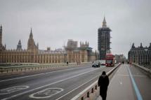 A pedestrian walks across a near-deserted Westminster Bridge in central London. Photo: (AFP)