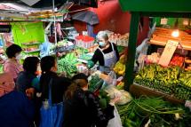 Shoppers buy vegetables a day after many shops ran out of some produce in Hong Hong on February 9, 2022, as stricter Covid-19 restrictions come into force following the city's highest infection numbers since the pandemic began. Photo: AFP