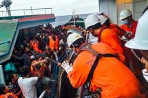 This picture released on November 8, 2022 by the Vietnam News Agency shows crew members of the Japan-flagged 'Helios Leader' vessel rescuing suspected migrants from Sri Lanka on board the Myanmar-flagged 'Lady 3' fishing vessel after it began taking on water, around 250 nautical miles off Vung Tau on Vietnam's southern coast. Photo: AFP