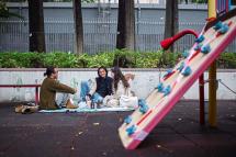 Breath of fresh air: (From left) Dominic, Bu and Birdy having a picnic at a public seating area next to a play area for children closed due to Covid-19 restrictions, in Hong Kong. Photo: AFP