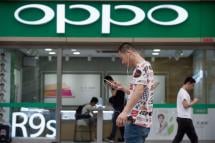 People walk in front of an Oppo shop in Shenzhen. Photo: AFP