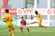 Phan Duc Thong (red shirt) of Pho Hien FC watches as Nguyen Vu Hoang Duong (right) of Thanh Hoa FC plays the ball during their Vietnamese National Football Cup qualifier match at the PVF stadium in Hung Yen in May after football resumed in Vietnam following a lockdown to halt the spread of coronavirus (AFP Photo/Nhac NGUYEN) 