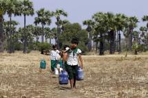 Children carry buckets to collect drinking water at Sapa village, in the outskirts of Mandalay. Photo: EPA