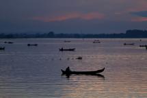 Fishermen sit in their boats near U Pain (U Bein) Bridge during the sunset time in Mandalay, Myanmar. Photo: EPA