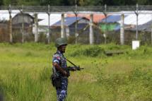 A Myanmar border guard police stands guard near the fence of Rohingyas refugees makeshift houses at the 'no man's land' zone between the Bangladesh-Myanmar border in Maungdaw district, Rakhine State, western Myanmar, 24 August 2018. Photo: EPA