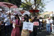 Women holding umbrellas and placards march in front of the US Embassy during a protest against the military coup, in Yangon, Myanmar, 10 February 2021. Photo: EPA