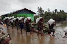 Workers carrying sack of rice in Maungtaw Township. Photo: MNA
